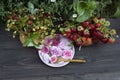 There are two bouquets of red ripe strawberries and forest white and red strawberries and a plate with a pink rose Royalty Free Stock Photo