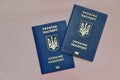 there are two Ukrainian passports on a pink background