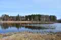 There is a unique village on the river bank. Wooden houses in the forest. Mixed forest of coniferous and deciduous