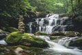 There is a waterfall behind and a pile of rocks in the foreground Royalty Free Stock Photo