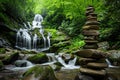 There is a waterfall behind and a pile of rocks in the foreground Royalty Free Stock Photo