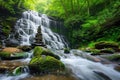There is a waterfall behind and a pile of rocks in the foreground Royalty Free Stock Photo