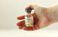 Theres a can of medicine in his hand. Grey medicine in capsules. The hand is stretched to the right. Home first aid kit. First Royalty Free Stock Photo