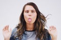 Theres a comedienne in all of us. Studio shot of a young woman making a funny face against a gray background. Royalty Free Stock Photo