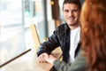 Theres love in his eyes. A cropped shot of a young affectionate couple on a coffee date.