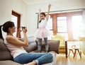 Theres never a dull moment with kids around. a mother taking a photo of her little daughter having fun at home.
