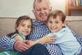 Theres no place like home, except at granddads. Portrait of a happy brother and sister giving their grandfather a loving Royalty Free Stock Photo