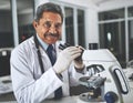 Theres no where to hide with this badboy. a mature scientist using a microscope in a laboratory. Royalty Free Stock Photo