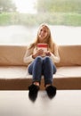 Theres nothing quite like a good book. Portrait of an attractive young woman holding a book while sitting on the sofa at Royalty Free Stock Photo