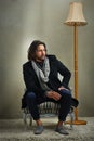 Theres nothing wrong with being old-fashioned. a stylishly dressed man sitting on a chair in the studio.