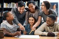 Theres power in cooperation. a group of young students working on an assignment together in a college library. Royalty Free Stock Photo
