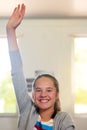 Theres a reason shes the teachers pet. Portrait of an enthusiastic schoolgirl raising her hand to answer a question in Royalty Free Stock Photo