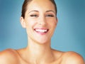 Theres something beautiful about happiness. Studio portrait of a beautiful young woman posing against a blue background.