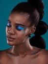 Theres something mesmerising about her beauty. Studio shot of a beautiful young woman posing against a turquoise