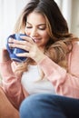 Theres something so soothing about a coffee break. a beautiful young woman having coffee while relaxing at home.