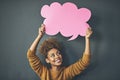 Theres something you should know. Studio shot of a young woman holding a thought bubble against a grey background.