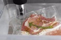 Thermal immersion circulator and vacuum packed meat in box, closeup. Sous vide cooking Royalty Free Stock Photo