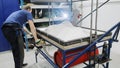 Thermoforming machine. The worker makes the form or part for the robot