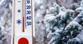 The thermometer on the background of the Christmas tree shows minus 35 degrees in winter. Difficult climates. Strong frost_ Royalty Free Stock Photo