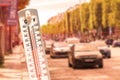 Thermometer in front of cars during heatwave
