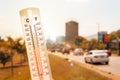 Thermometer in front of cars and traffic during heatwave Royalty Free Stock Photo