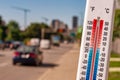 Thermometer in front of cars and traffic during heatwave Royalty Free Stock Photo