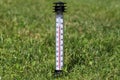 Thermometer on the grass indicating a high temperature