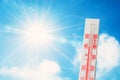 Thermometer is hot in the sky bright sun, glowing rays, concept of extreme weather Royalty Free Stock Photo