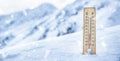 Thermometer on the mountains in the snow shows temperatures below zero. Low temperatures in degrees Celsius and fahrenheit in Royalty Free Stock Photo