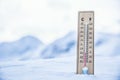 Thermometer on the mountains in the snow shows temperatures below zero. Low temperatures in degrees Celsius and fahrenheit