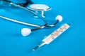 Thermometer and phonendoscop on a blue background Royalty Free Stock Photo