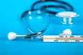 Thermometer and phonendoscop on a blue background Royalty Free Stock Photo
