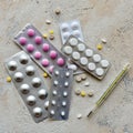 Thermometer and pill packs on a stone background.