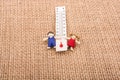 Thermometer between a boy and a girl figurine Royalty Free Stock Photo