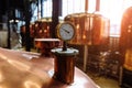 Thermometer or pressure gauge on copper colored brewery tanks close up