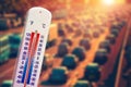 Thermometer showing high temperature in front of traffic during heatwave