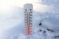 Thermometer on snow shows freezing temperature in celsius or farenheit Royalty Free Stock Photo