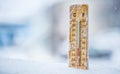 Thermometer on snow shows low temperatures in celsius or farenheit