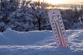 Thermometer on snow shows low temperatures in celsius or farenheit. On the Sunset Royalty Free Stock Photo