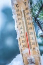 Thermometer on snow shows low temperatures in celsius or farenheit Royalty Free Stock Photo