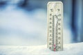 Thermometer on snow shows low temperatures under zero. Low temperatures in degrees Celsius and fahrenheit. Royalty Free Stock Photo