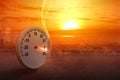 The thermometer on the street with a high temperature on the city with a glowing sun background Royalty Free Stock Photo