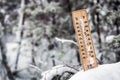 Thermometer with subzero temperature stuck in the snow in the winter