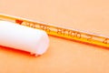 Thermometer and suppository medication on orange. Rectal drug administration.