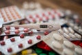 A thermometer with a temperature of 36.6 lies on a pile of tablets Royalty Free Stock Photo