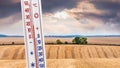 A thermometer on a wheat field background shows 20 degrees of heat. Rainy weather. Summer weather