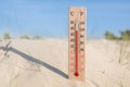 Wooden celsius and fahrenheit scale thermometer in the sand. Ambient temperature plus 38 degrees