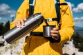 A thermos in the hands of a traveler. Travel and camping concept Royalty Free Stock Photo