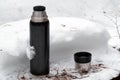 Thermos with open cup on the snow Royalty Free Stock Photo