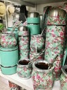 Thermos with pink and white flowers and teal background with straws, Mate cups